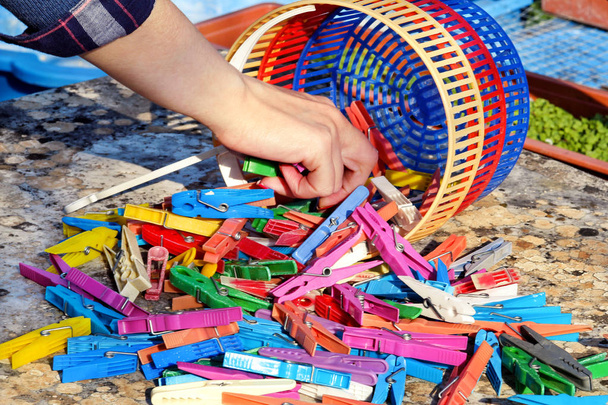 Рука бере барвисті прищіпки стояти на столі в саду
 - Фото, зображення