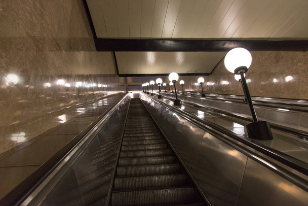 Ескалатор в метро підйом з освітлювальними лампами на
 - Фото, зображення
