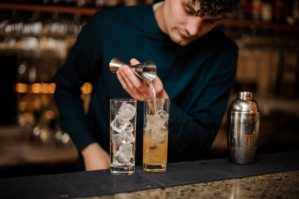 bartender with curly hair begins preparing two alcoholic cocktails - Fotografie, Obrázek