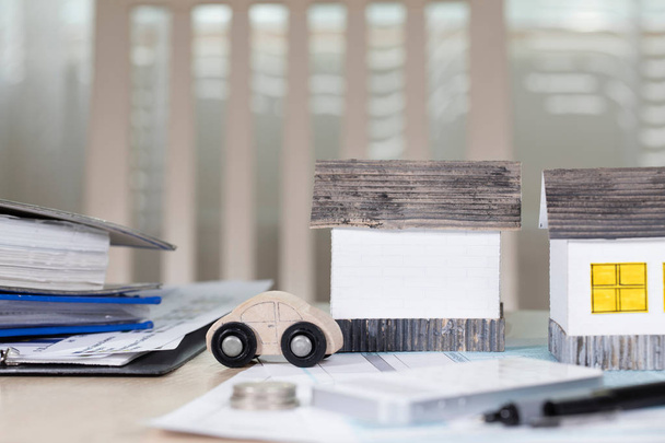 Casas de papel hechas a mano sobre la mesa. Papeles, pluma, calculadora, monedas
  - Foto, imagen