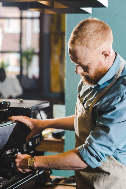 giovane barbuto maschio barista in grembiule con macchina da caffè
  - Foto, immagini