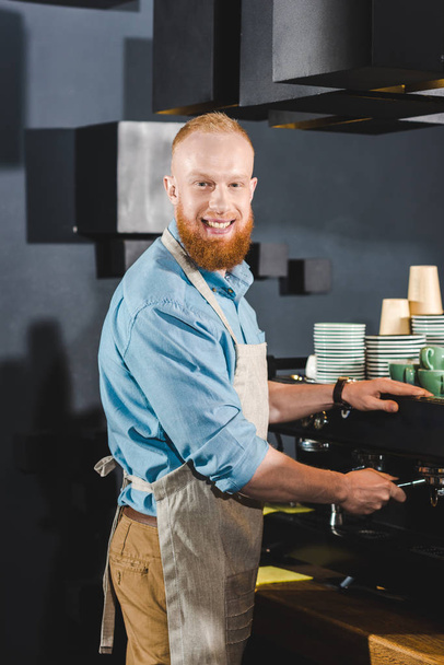 genç erkek barista kahve makinesi kahve dükkanında yapıyor gülümseyen  - Fotoğraf, Görsel