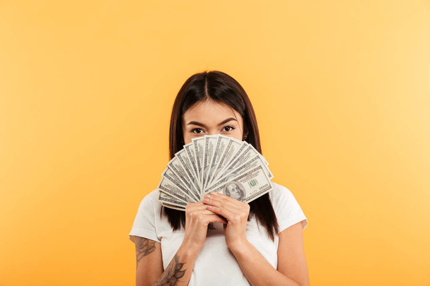 Pretty young woman covering face with money. - Foto, Imagen