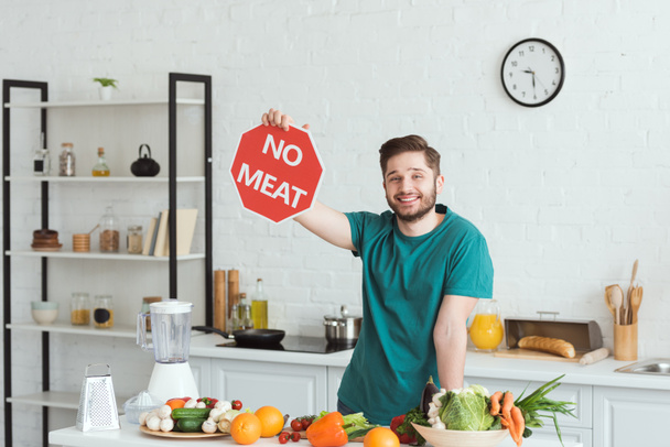 handsome vegan man showing no meat sign in kitchen - 写真・画像
