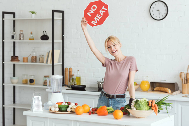 attractive vegan girl showing no meat sign in kitchen - Фото, изображение