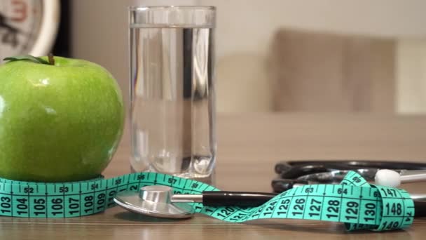 Nahrung für Gesunde. Apfel, Wasser und Stethoskop. - Filmmaterial, Video