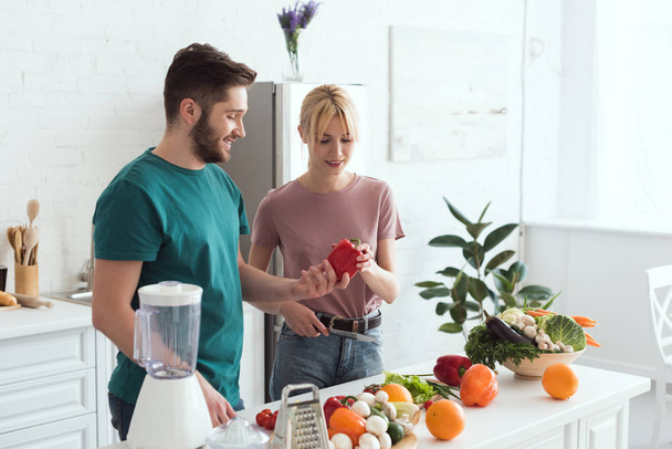пара вегетарианцев смотрят на красный перец на кухне
 - Фото, изображение
