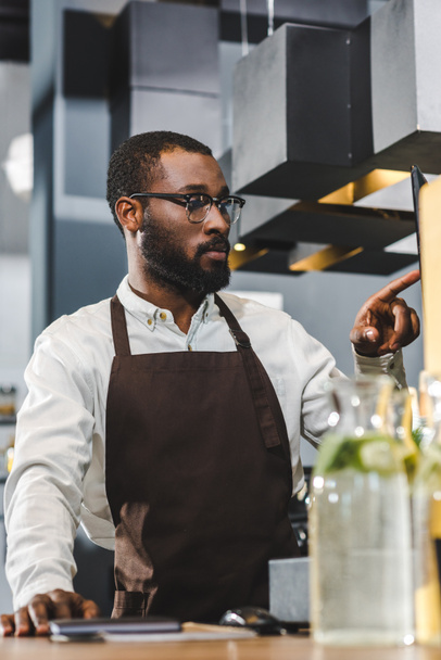 handsome young african american barista in eyeglasses working in coffee shop - Photo, Image
