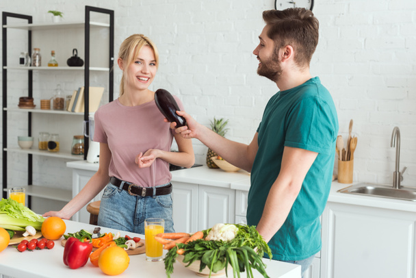 парень, использующий баклажаны в качестве микрофона и весело провести время на кухне, веганская концепция
 - Фото, изображение