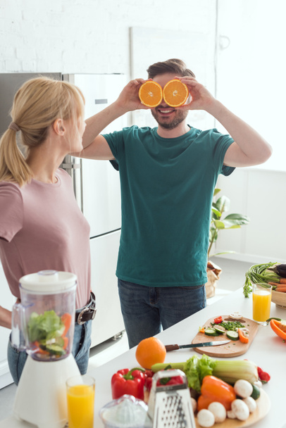 poikaystävä hauskaa ja kattavat silmät oranssi kappaletta keittiössä, vegaani käsite
 - Valokuva, kuva