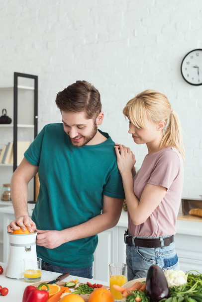 happy boyfriend preparing fresh juice at kitchen, vegan concept - Φωτογραφία, εικόνα
