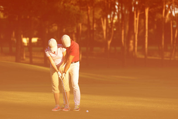 male golf instructor teaching female golf player on golf course - Valokuva, kuva