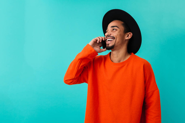 Cheerful young african man talking by phone. - 写真・画像
