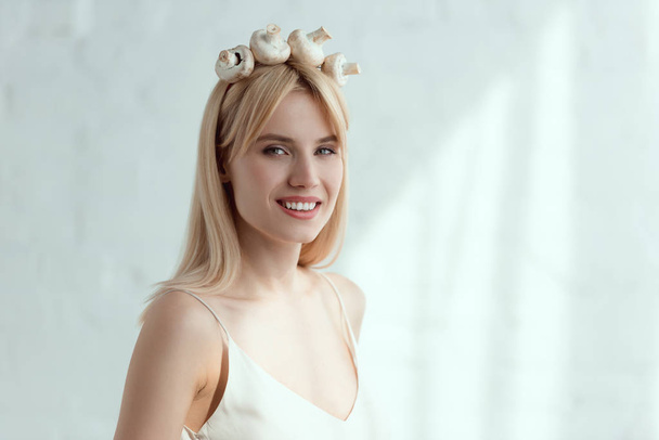 bonita mujer sonriente en vestido con corona hecha de champiñones frescos en la cabeza, concepto de estilo de vida vegano
 - Foto, imagen