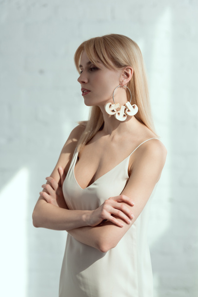 bella donna pensierosa in abito con orecchino fatto di funghi, concetto di stile di vita vegan
 - Foto, immagini
