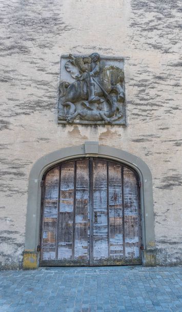 old handmade medieval wooden gate with a commemorative town seal above in an idyllic small European village - Photo, Image