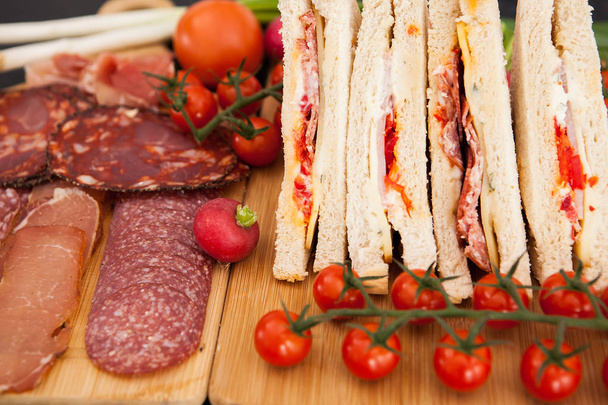 Club sandwiches liggend op een houten plank - Foto, afbeelding