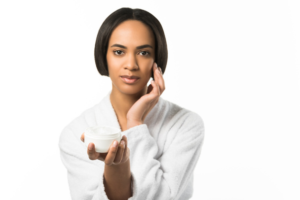 bela mulher afro-americana aplicando creme facial, isolado em branco
 - Foto, Imagem