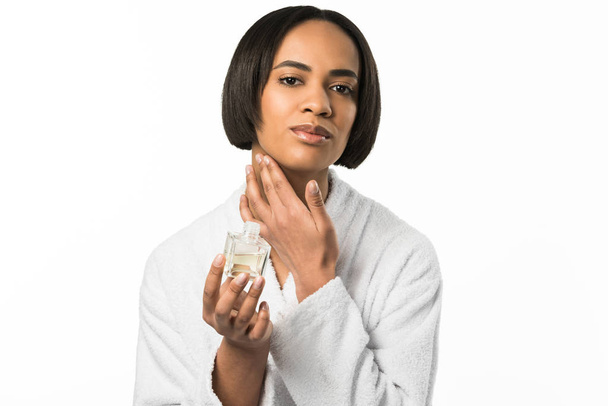 魅力的なアフリカ系アメリカ人女性は白で隔離の首に香水を適用します。 - 写真・画像