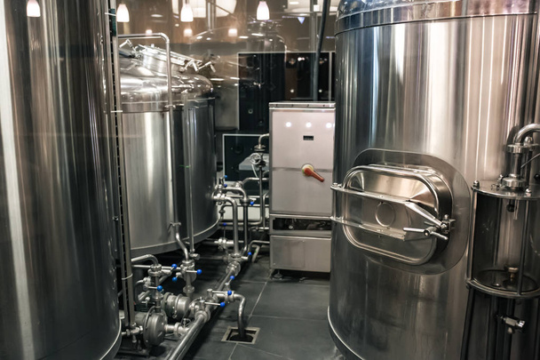 Brewery manufacturing factory. Stainless steel vats or tanks with pipes, small brewing equipment, modern alcohol production technology - Photo, Image