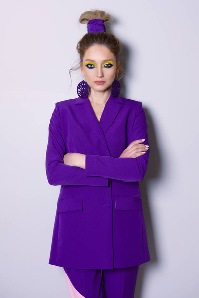 Fashion model standing near the wall with poker face in casual violet suit - Foto, immagini