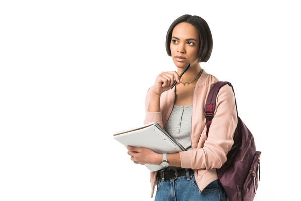 nachdenkliche afrikanisch-amerikanische Studentin mit Rucksack und Copybook, isoliert auf weiß - Foto, Bild