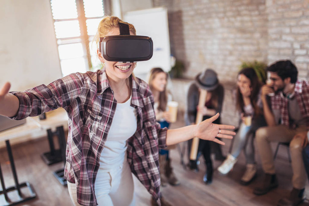Empresários que fazem exercício de treinamento em equipe durante o seminário de formação em equipe usando óculos VR
 - Foto, Imagem