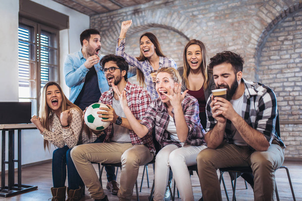 Happy přátelé nebo fotbalový fanoušci sledují fotbal v televizi a slaví vítězství. Koncept přátelství, sportu a zábavy. - Fotografie, Obrázek