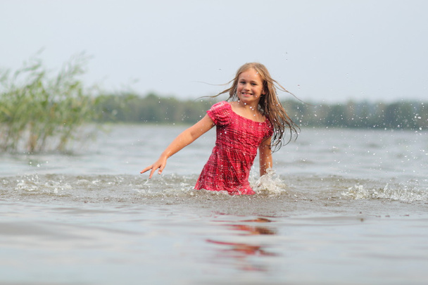 Kaunis emotionaalinen tyttö lapsi mekko ui vedessä
 - Valokuva, kuva