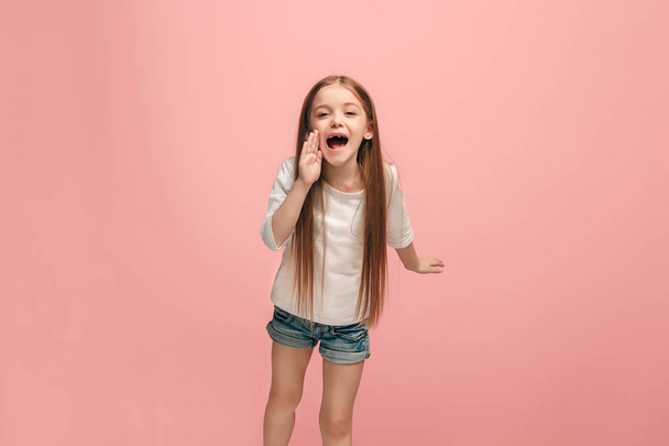 Isolated on pink young casual teen girl shouting at studio - Фото, зображення