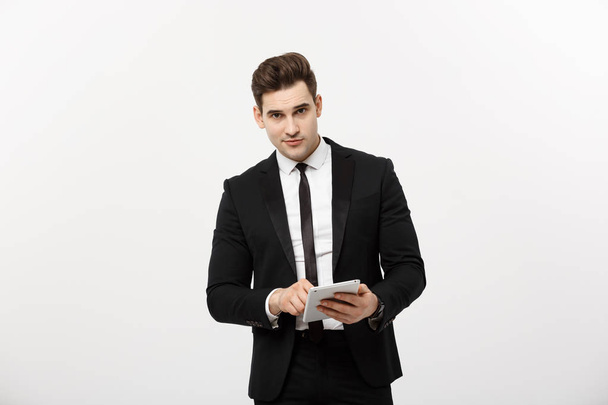 Checking statistics. Successful and confident businessman stands and checks online news on the tablet inside business center. Young business in formal suit. - Foto, Bild