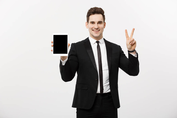 Feliz hombre de negocios mostrando dos dedos o gesto de victoria sosteniendo la tableta, sobre fondo gris. Éxito en el concepto empresarial, laboral y educativo. Área de copyspace en blanco para publicidad, eslogan o texto
 - Foto, imagen