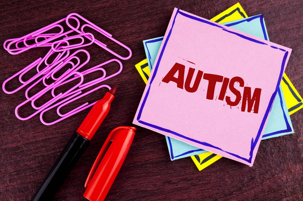 Текст слова Аутизм. Бизнес-концепция информированности о аутизме, проводимая социальным комитетом по всему миру, написана на розовой липкой бумаге для заметок на деревянном фоне
 - Фото, изображение