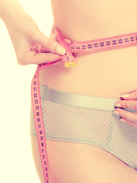 Mulher em lingerie medindo sua cintura com fita métrica
. - Foto, Imagem