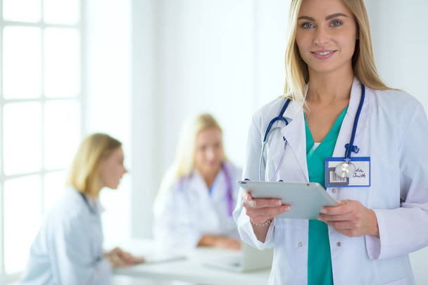portrait of a young female doctor, with aipads in hand, in a medical office - Foto, imagen
