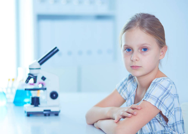 Schoolgirl looking through microscope in science class. - Photo, image