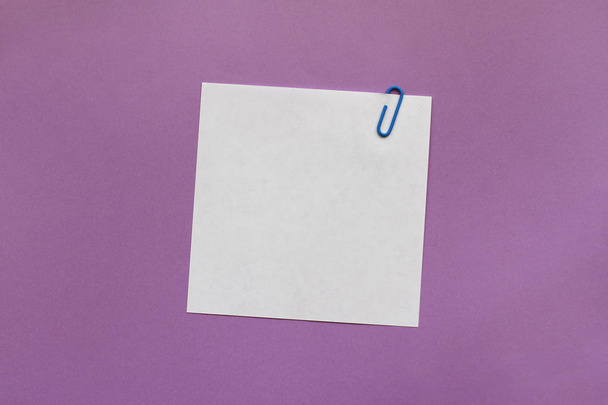 White note paper label with clip on purple background - Foto, Bild