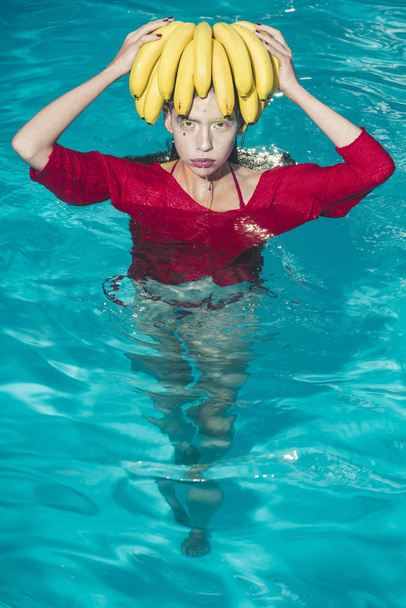 Dieting and healthy organic food, vegetarian. dieting with fresh banana fruit of woman in pool - Photo, image