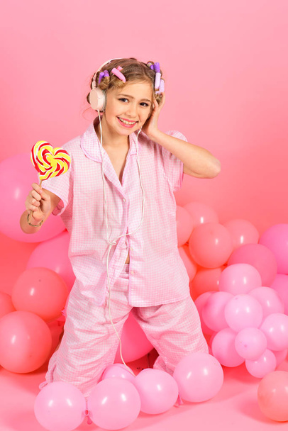 Boldog kis lány nyalóka stúdióban rózsaszín háttér - Fotó, kép