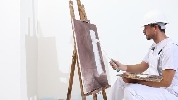 pintor hombre en el trabajo con rodillo de pintura, caballete, lienzo y paleta, concepto de pintura de pared, fondo de espacio de copia blanca
 - Metraje, vídeo