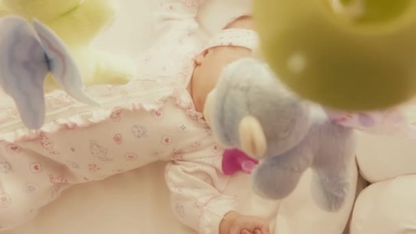 Bebé niña mirando desenfocado juguete móvil en su cuna
 - Metraje, vídeo