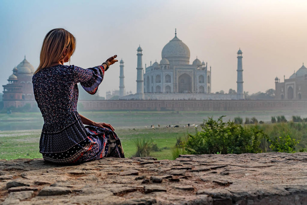 Kaunis tyttö osoittaa Taj Mahalia. Matkustuskäsite - Valokuva, kuva