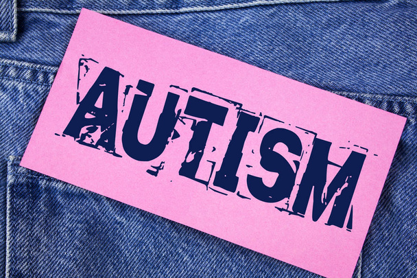 Handgeschreven tekst autisme. Begrip betekenis van autisme bewustzijn, olv Sociaal Comité over de hele wereld geschreven op kleverige nota papier op de achtergrond van de Jeans. - Foto, afbeelding