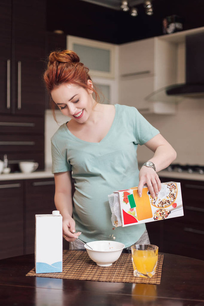 Smiling pregnant woman preparing breakfast, - Fotó, kép