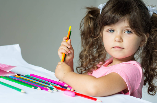 schattig kind tekent met de kleur potloden - Foto, afbeelding