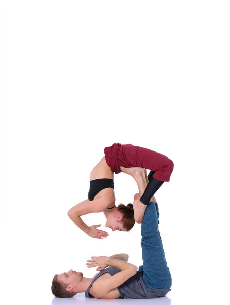 Young athletic couple practicing acroyoga. Balancing in pair - Foto, afbeelding