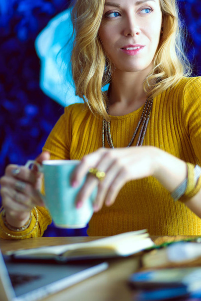 Young woman on a coffee break or enjoying the coffee-break, Using laptop computer - Foto, afbeelding