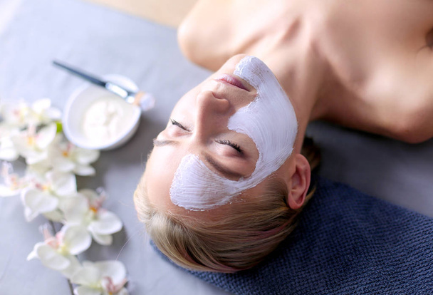 Máscara de rosto.Menina bonita no spa, mulher cosmetician aplicando máscara facial
 - Foto, Imagem