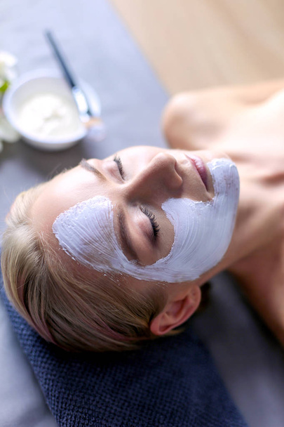 Face mask.Beautiful young girl at spa ,cosmetician woman applying facial mask - Foto, Imagem