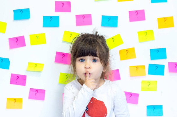 Cute child with question symbol on stickers around. Education concept. - Photo, Image